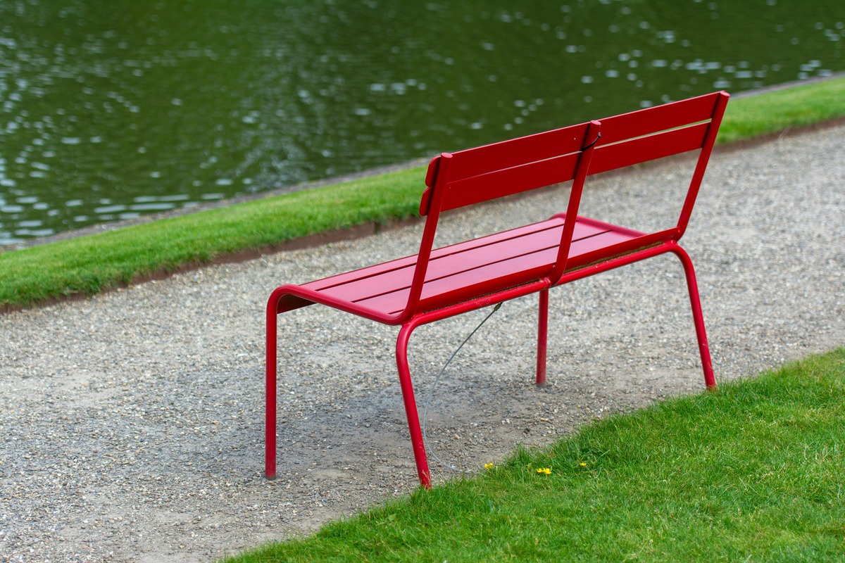 Tuini Winkel -Tuini Winkel free photo of an empty red bench by a body of water in a park 1 1